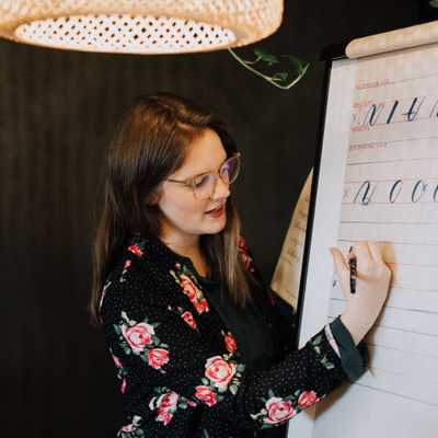 Toronto special event calligrapher poses for a head shot with calligraphy tools.